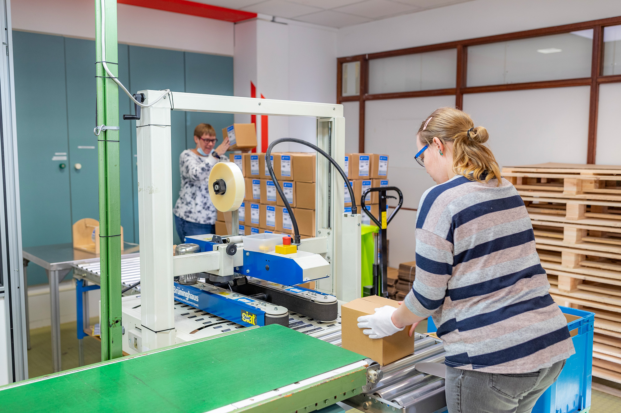 Frau an einer Verpackungsmaschine Frau an einer Verpackungsmaschine